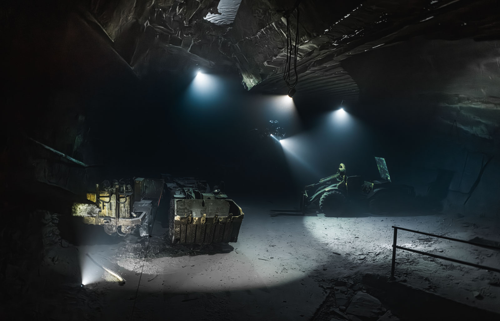Taucher und Lichtstrahlen über einer alten Maschine in einer Bergwerkshalle